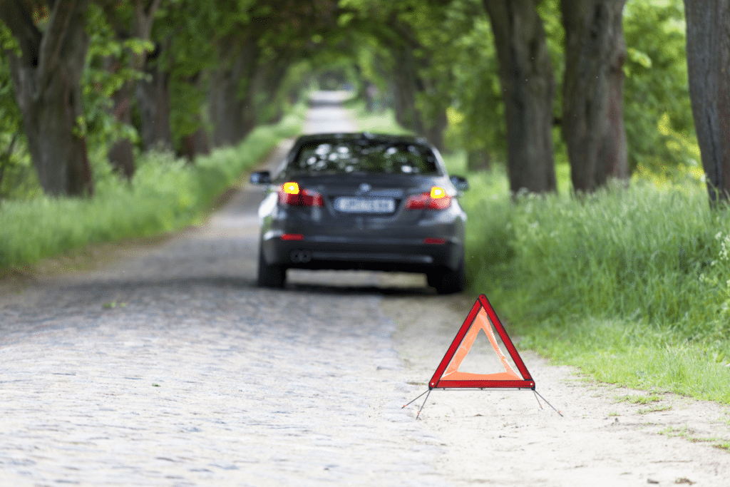 Sichern Sie eine befahrene Straße ab, wenn Sie einem Auto dort Starthilfe geben.