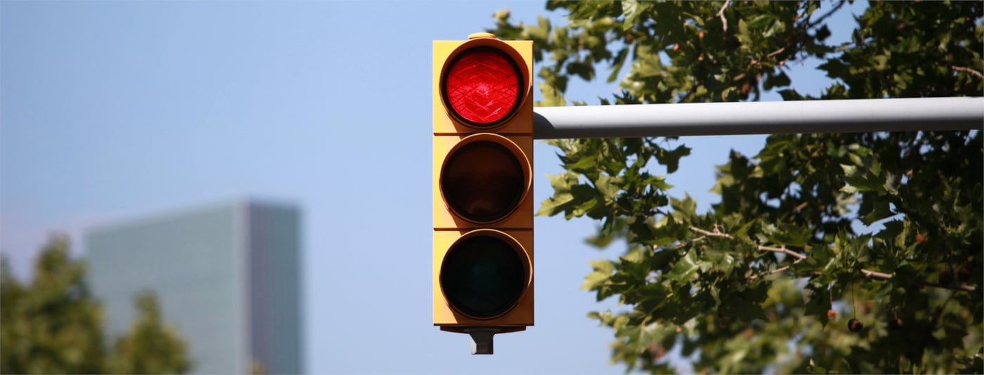 Das Handy am Steuer vor einer roten Ampel zu halten, ist untersagt.